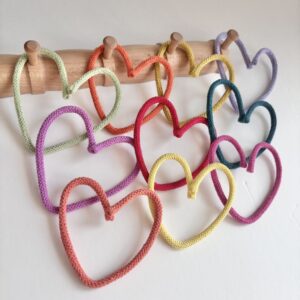 Colorful decorative hearts hanging on peg rail in kids room decor