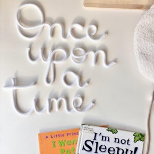 White once upon a time sign above cozy nursery reading nook with bookshelves