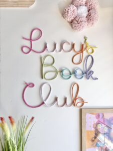 Pastel kids book club sign decorating soft Montessori style reading corner