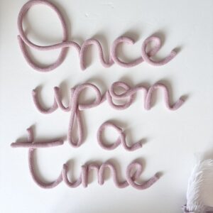 Blush pink once upon a time sign above girls nursery reading nook