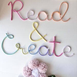 Read and create pastel wall sign displayed in colorful kids reading nook