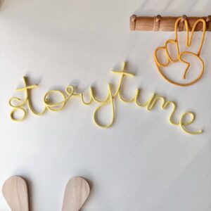Storytime wall sign in solid color above kids reading nook with books