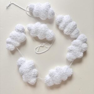 Handmade white boucle cloud garland hanging in neutral nursery above crib