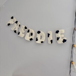 Personalized cow print name banner with black and white spots for kids room decor