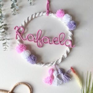 baby girl name decoration with pom poms around it and name in the middle