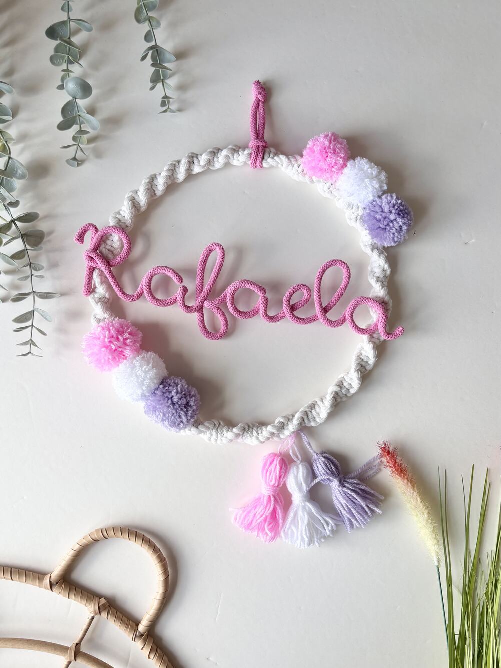 baby girl name decoration with pom poms around it and name in the middle