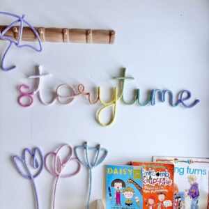 Pastel storytime sign with multicoloured letters for nursery reading corner wall decor