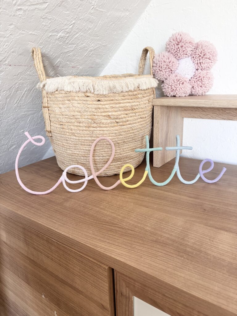 pastel name sign Colette rested on a shelf in nursery