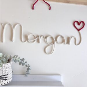 Personalized name sign with a heart for a baby nursery in custom colours.