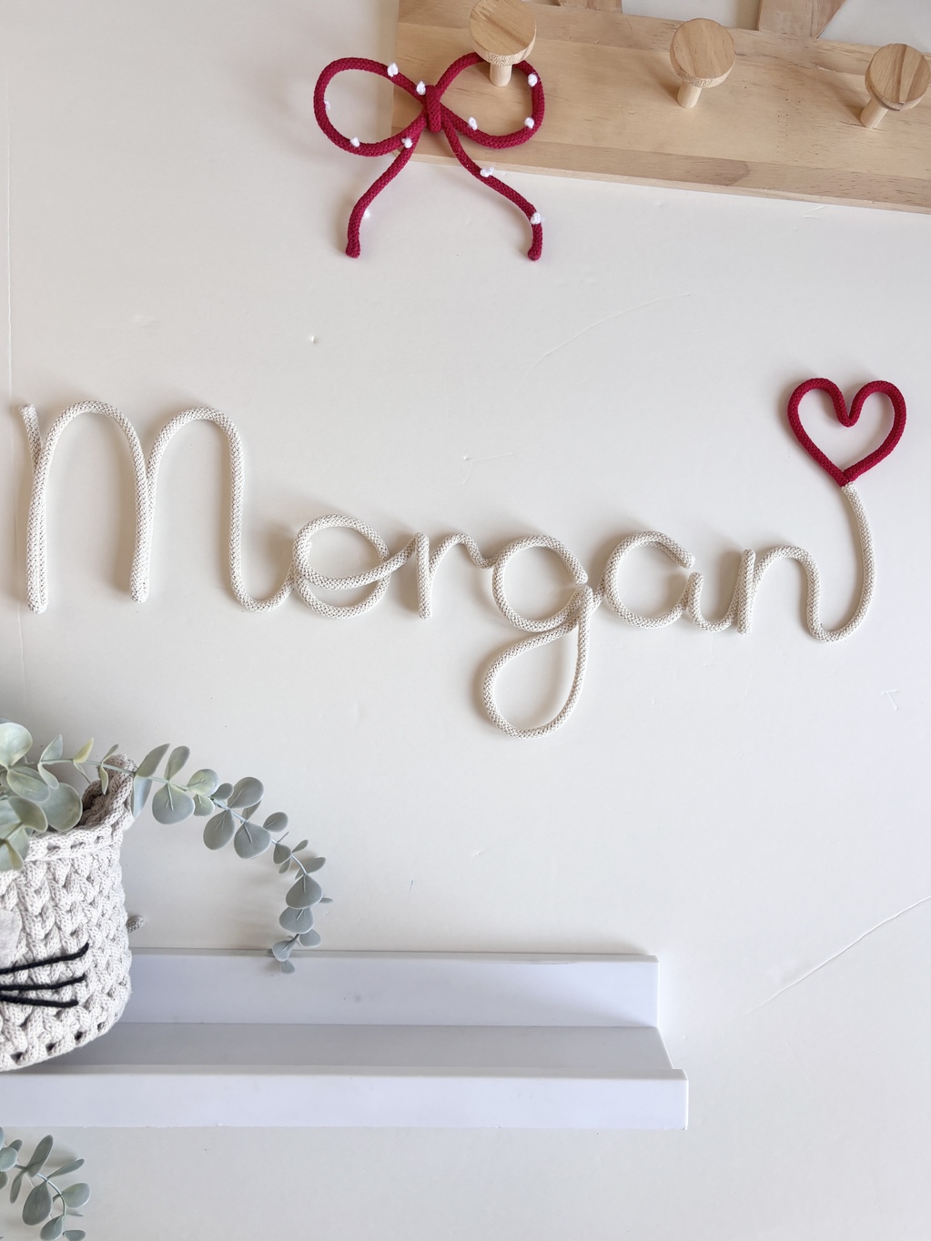 Personalized name sign with a heart for a baby nursery in custom colours.