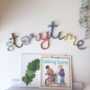 Colourful Storytime sign for a children's reading corner, handmade wall decor for a nursery, playroom, or classroom.