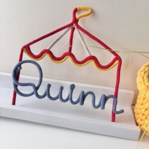 Personalised vintage circus tent wall decoration with custom name, handmade nursery decor for a child's bedroom.