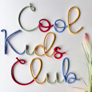 Cool Kids Club colourful wall sign hanging in a children's playroom